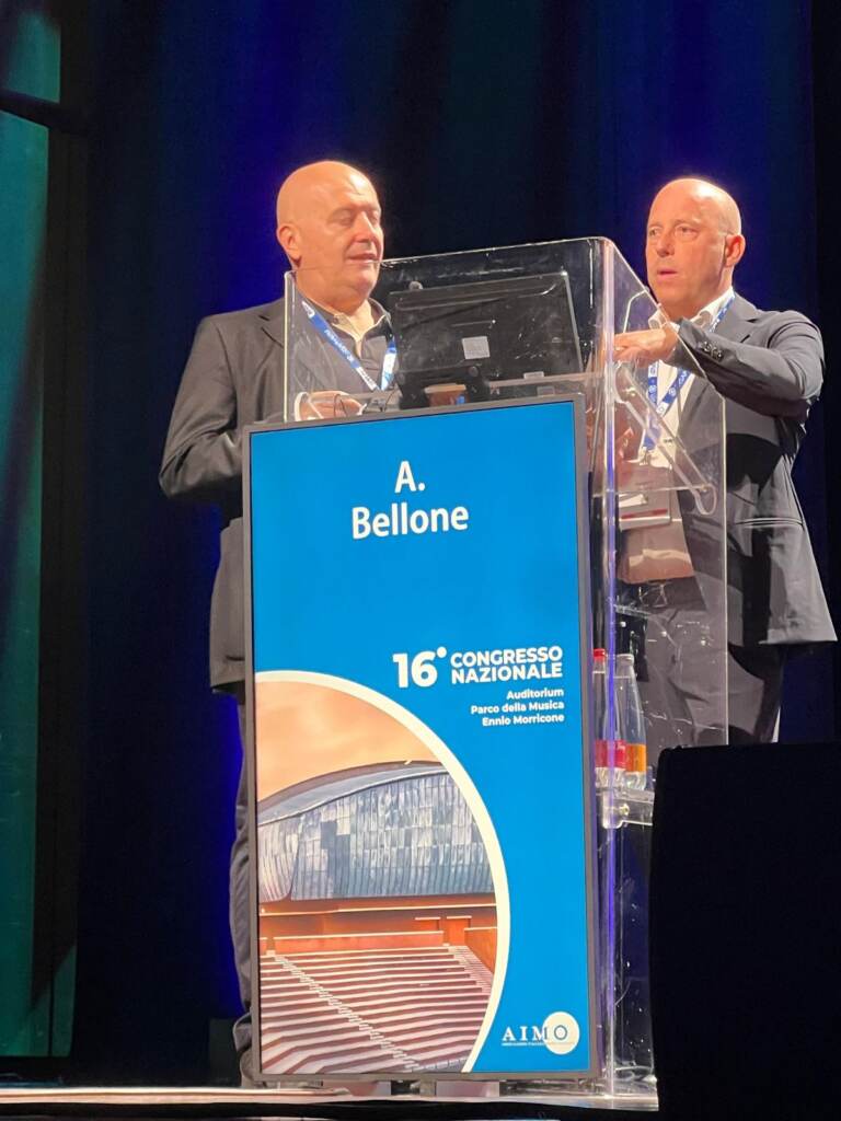 Il Dott. Alberto Bellone e il collega Dott. Galli, suo paziente, al podio del 16° Congresso Nazionale AIMO 2026